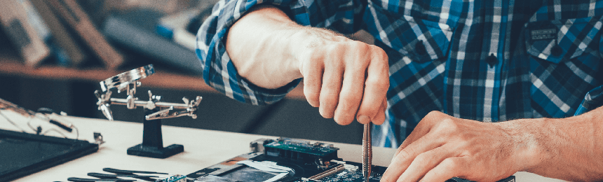 Computer repair shop. Engineer performing laptop maintenance. Hardware developer fixing electronic components. PC technology